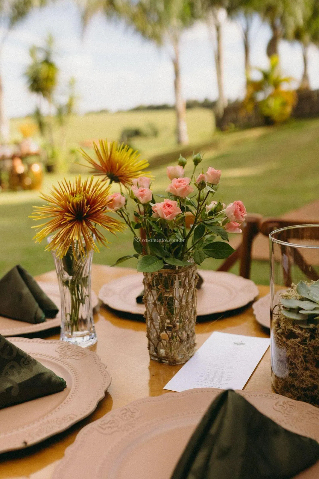 Detalhe de arranjos de flores do campo e taças sobre a mesa