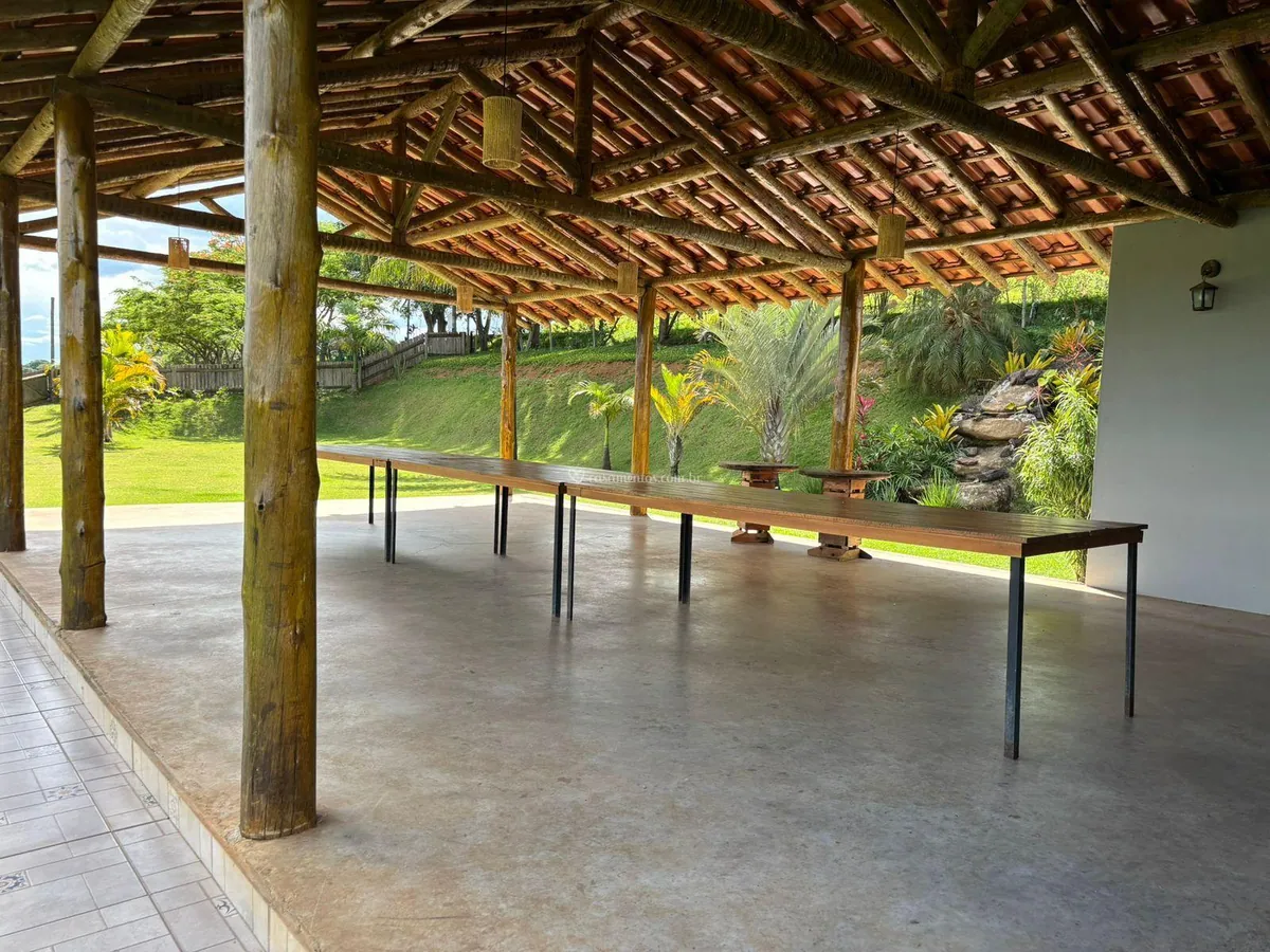 Salão coberto com estrutura de madeira aberto para o jardim