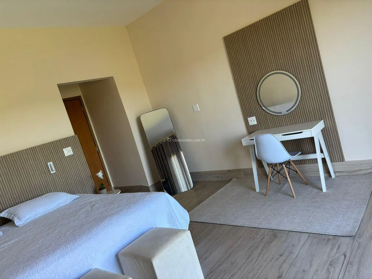 Suíte com cama, penteadeira e espelho iluminado